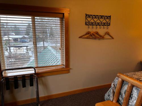 a bedroom with a window and a window at Chewuch Inn & Cabins in Winthrop