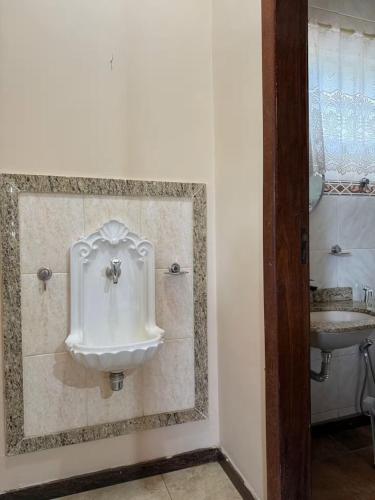 a bathroom with a urinal next to a sink at Sitio descanso da Serra in Jaboticatubas