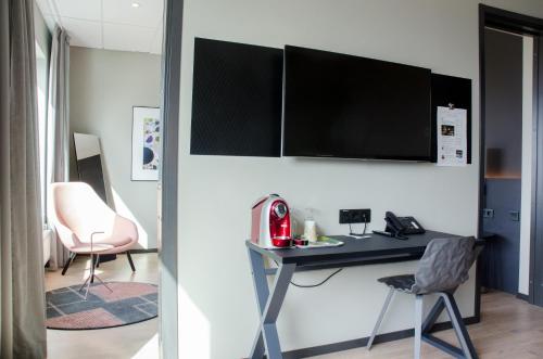 a room with a desk and a tv on a wall at Frösö Park Hotel in Östersund