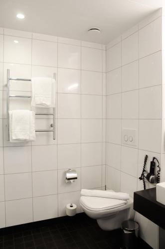 a white bathroom with a toilet and a sink at Frösö Park Hotel in Östersund