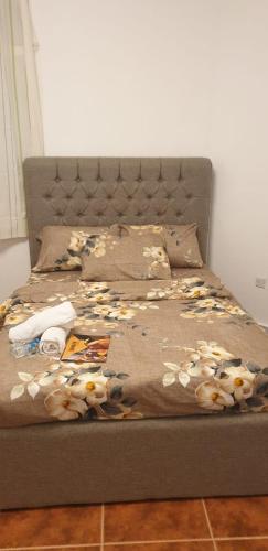 a bed with a blanket with flowers on it at International Abu-Dhabi Hostel Villa in Abu Dhabi