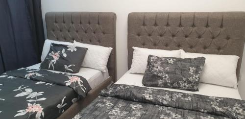 a bedroom with two beds and a headboard at International Abu-Dhabi Hostel Villa in Abu Dhabi