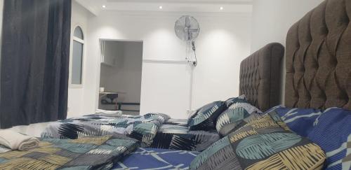 a bedroom with two beds and a clock on the wall at International Abu-Dhabi Hostel Villa in Abu Dhabi