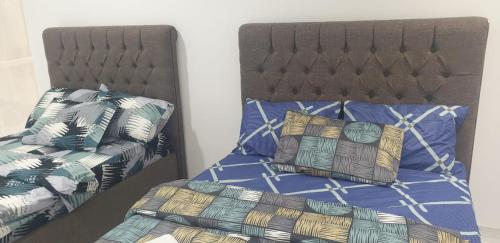 a bedroom with two beds and a bed with pillows at International Abu-Dhabi Hostel Villa in Abu Dhabi