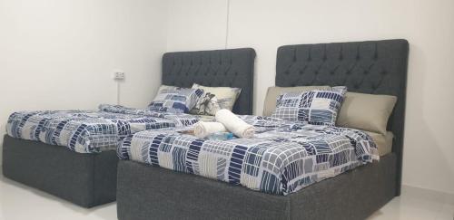a bed with blue and white blankets and pillows at International Abu-Dhabi Hostel Villa in Abu Dhabi