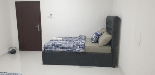 a bed with a headboard and pillows on it in a room at International Abu-Dhabi Hostel Villa in Abu Dhabi