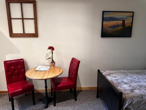 a room with a table and two chairs and a bed at Chewuch Inn & Cabins in Winthrop