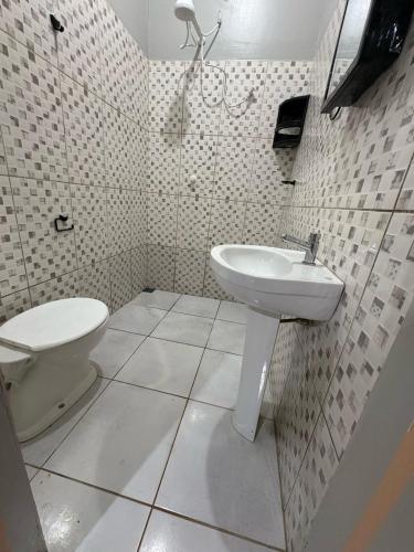 a bathroom with a toilet and a sink at Spacious and comfortable apartment in Oiapoque