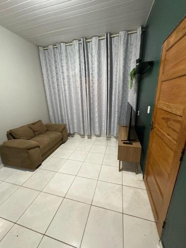 a living room with a couch and a television at Spacious and comfortable apartment in Oiapoque