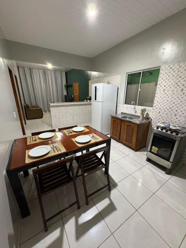 a kitchen with a table and a kitchen with a refrigerator at Spacious and comfortable apartment in Oiapoque