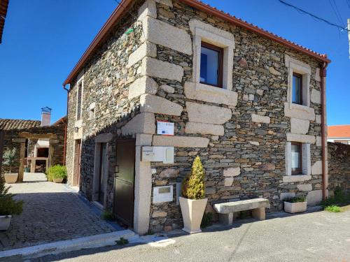 a stone building with a bench in front of it at Casa da Avó Ana in Prado Gatão