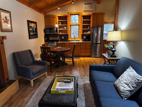 a living room with a blue couch and a kitchen at Chewuch Inn & Cabins in Winthrop