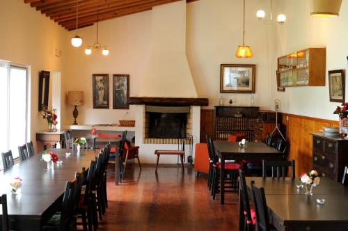 a dining room with tables and chairs and a fireplace at Quinta dos Sabores Farm Houses in Ribeira Grande