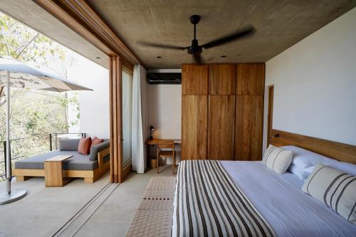 a bedroom with a bed and a couch at El Guayacan in Zipolite