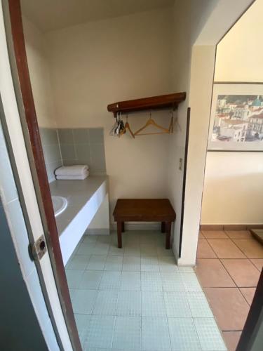 a bathroom with a sink and a bench in it at Hotel Posada Santa Fe Sabinas in Sabinas