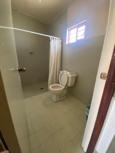 a bathroom with a toilet and a window at Hotel Posada Santa Fe Sabinas in Sabinas