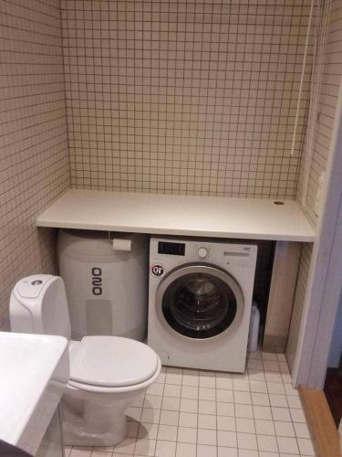 a bathroom with a toilet and a washing machine at Stylish urban apartment in Stavanger