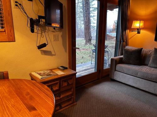 a living room with a couch and a table at Chewuch Inn & Cabins in Winthrop