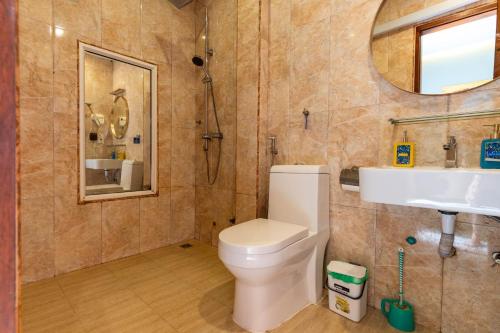 a bathroom with a toilet and a sink and a mirror at Maamadi Boutique in Maafushi