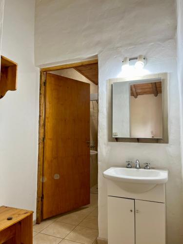 Un baño con lavabo y puerta de madera. en La Serena, en San Rafael