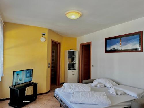 a living room with two beds and a flat screen tv at 1Dest - Sweet Spot in Riva del Garda