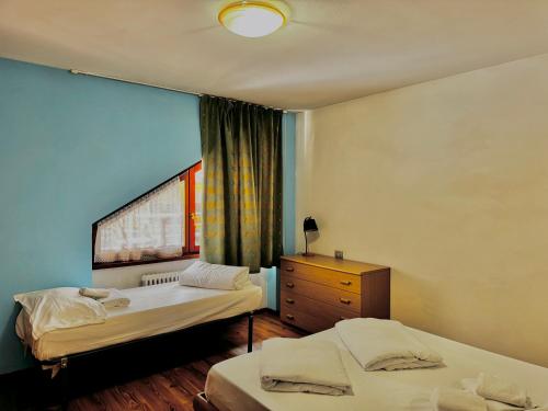 a bedroom with two beds and a dresser and a window at 1Dest - Sweet Spot in Riva del Garda