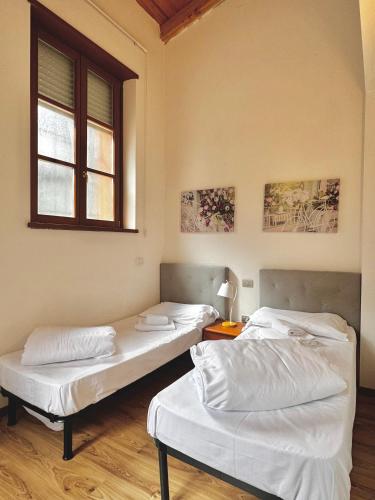 three beds in a room with a window at 1Dest - Sweet Spot in Riva del Garda