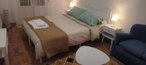a bedroom with a bed with green pillows and a chair at La consulta de Paloma, Plaza encanto historico in Riaza