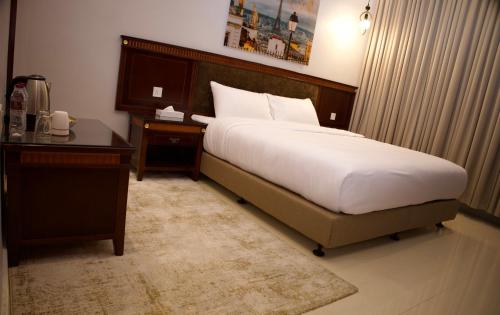 a bedroom with a bed and a desk and a bed sidx sidx sidx at الموج للشقق الفندقية in Falaj al Qabāʼil