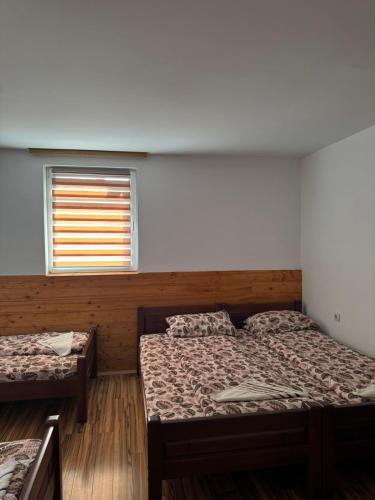 a room with two beds and a window at Guest House Ethno Village Milogora in Pluzine