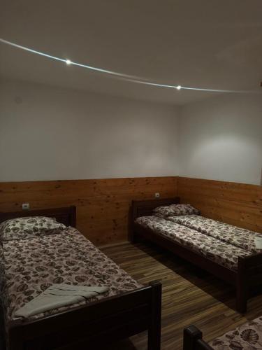 a room with two beds in a room with lights at Guest House Ethno Village Milogora in Pluzine