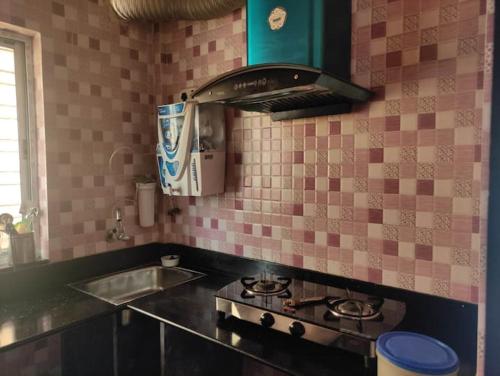 a kitchen with a stove and a sink at Luxury penthouse on budget in Kolkata