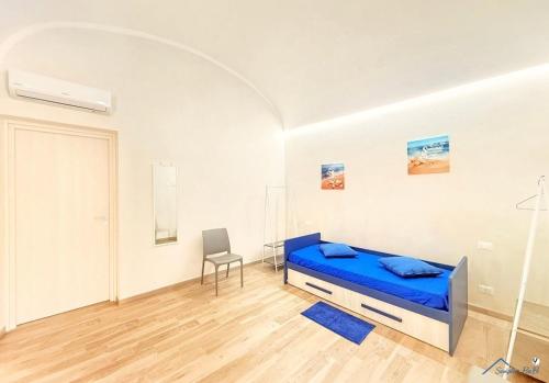 a bedroom with a blue bed and a chair at Sicilia bedda in Custonaci