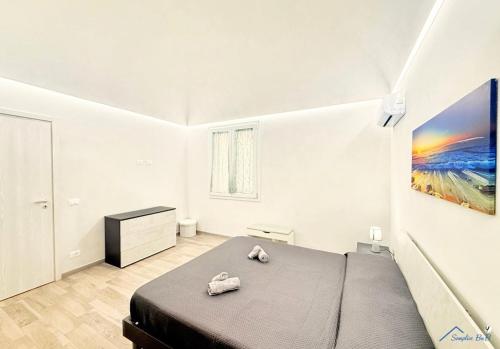 a bedroom with a bed and a painting on the wall at Sicilia bedda in Custonaci
