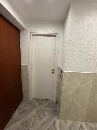 a white door in a room with a tile floor at LUXOR ECO ROMA CASA E APPARTAMENTO PER VACANZE IN CENTRO Piazza Bologna, Colosseo, Piazza di Spagna, Vaticano, San Pietro, Sapienza, Fontana di Trevi, Piazza Navona, Trastevere, Tiburtina, Termini, Aeroporto in Rome
