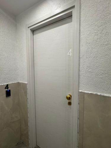 a door with the number four on it in a bathroom at LUXOR ECO ROMA CASA E APPARTAMENTO PER VACANZE IN CENTRO Piazza Bologna, Colosseo, Piazza di Spagna, Vaticano, San Pietro, Sapienza, Fontana di Trevi, Piazza Navona, Trastevere, Tiburtina, Termini, Aeroporto in Rome