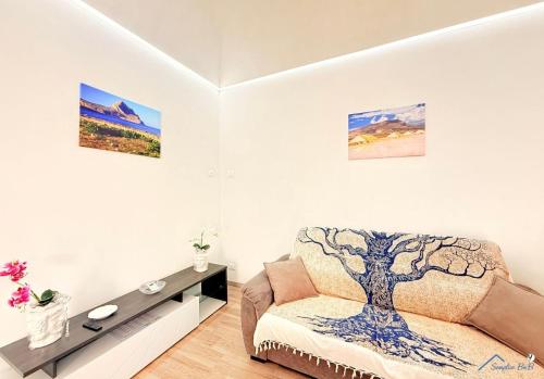 a living room with a chair and a tree on the wall at Sicilia bedda in Custonaci