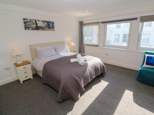 a bedroom with a bed with a stuffed animal on it at Flat 1 in Penzance