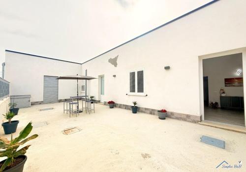 a white building with a patio with a table and chairs at Sicilia bedda in Custonaci