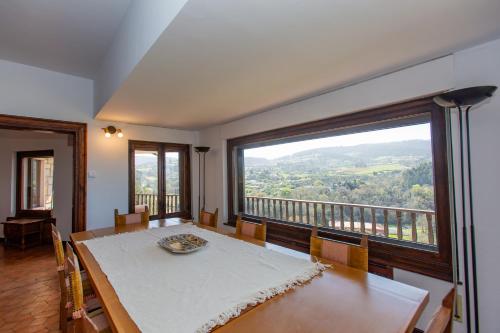 a dining room with a table and a large window at Finca Tolombreo Casa Gabriel in Cudillero