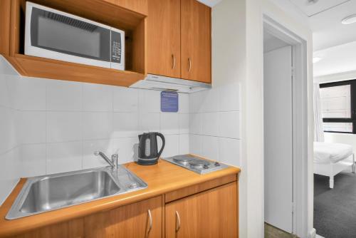 a kitchen with a sink and a microwave at 1 Valentine Ave in Sydney