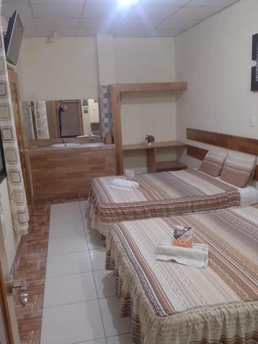 a room with three beds and a bathroom at Casa Nativa Iquitos in Iquitos