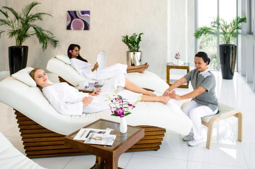 a group of people sitting on a couch in a living room at Novotel Abu Dhabi Gate in Abu Dhabi