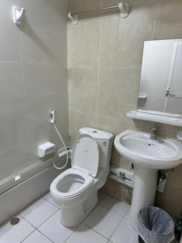 a bathroom with a toilet and a sink at International Abu Dhabi Hostel in Abu Dhabi