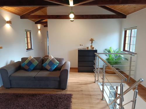 a living room with a couch and a staircase at Casa Terra & Mar in Urzelina