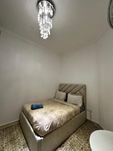 a bed in a room with a chandelier at International Abu Dhabi Hostel in Abu Dhabi
