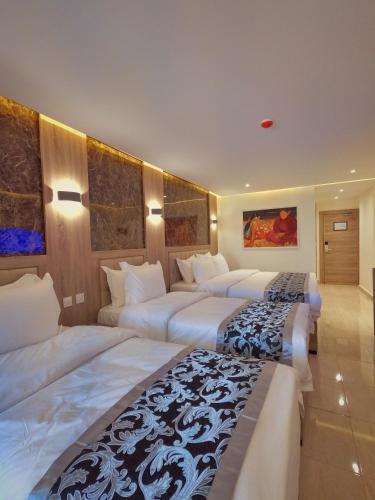 a hotel room with three beds in it at Grand Season Hotel in Aqaba
