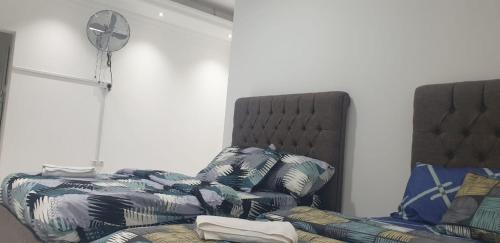 a living room with a bed and a fan at International Abu Dhabi Hostel in Abu Dhabi