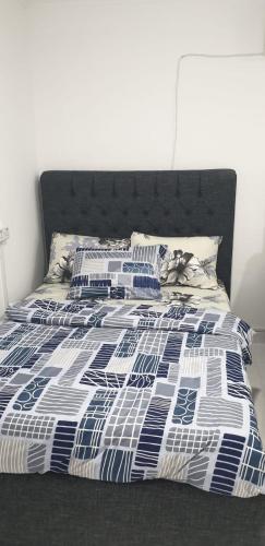 a bed with a blue and white comforter and pillows at International Abu Dhabi Hostel in Abu Dhabi