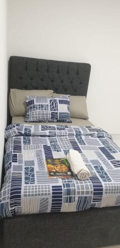 a bed with a blue and white comforter and pillows at International Abu Dhabi Hostel in Abu Dhabi
